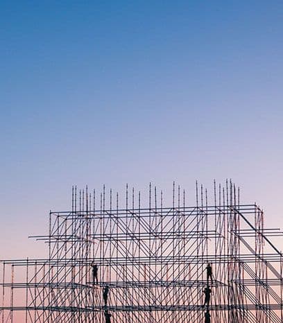 A building under construction with scaffolding against a blue sky