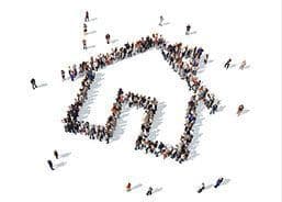 A large group of people are standing in the shape of a house.