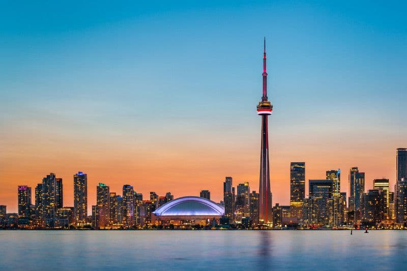 Toronto, Ontario skyline with the CN tower in the foreground and a large body of water