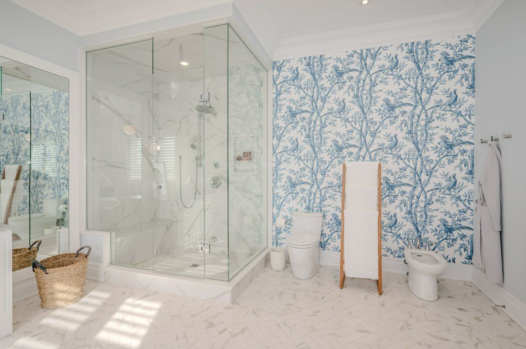 A bathroom with a walk in shower , toilet , and bidet.
