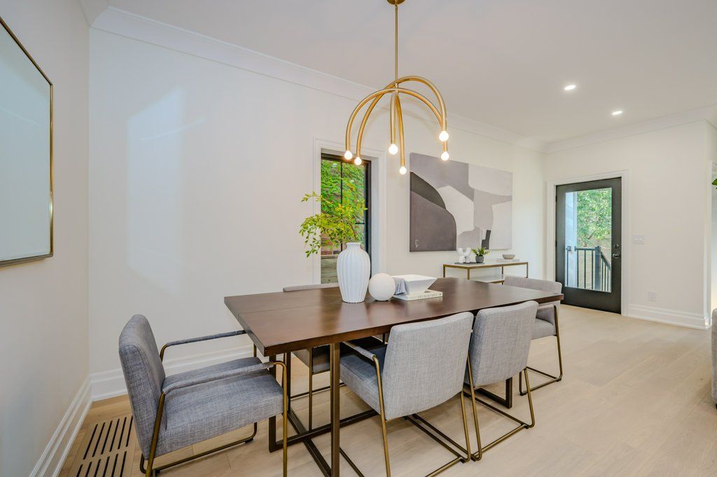 A dining room with a long table and chairs and a chandelier.