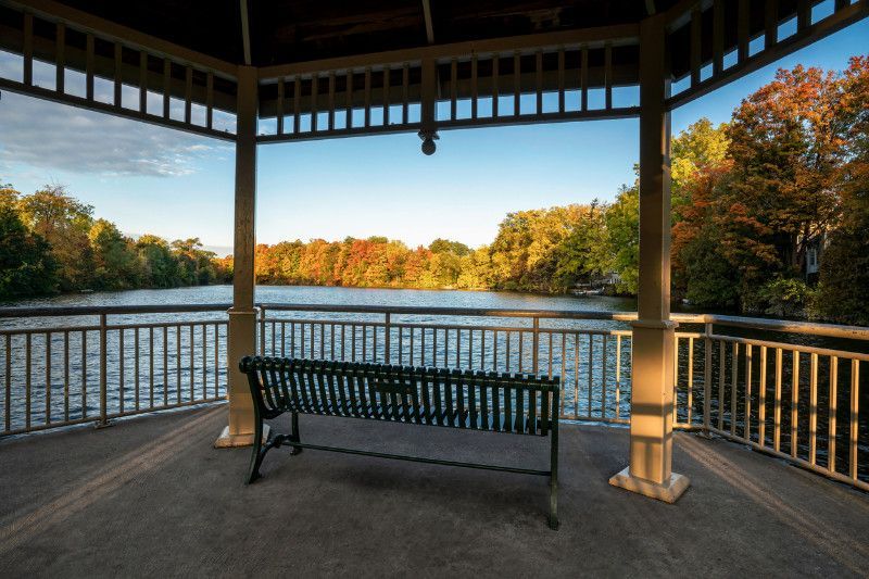 A gazebo with a bench overlooking a lake