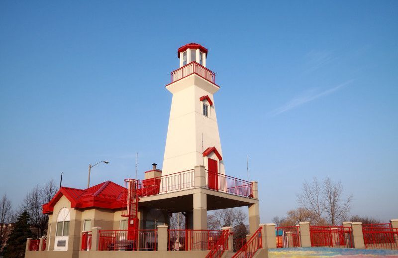 A white and red lighthouse with a red roof