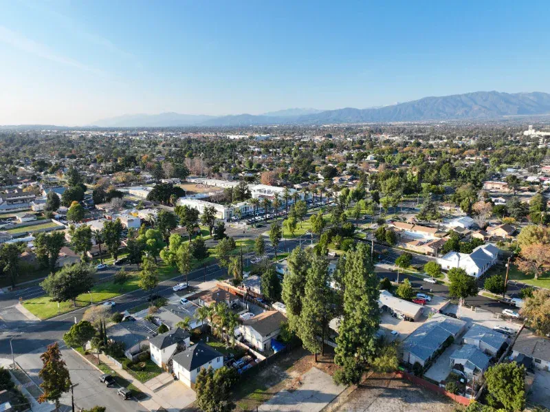 An aerial view of a residential area with mountains in the background.