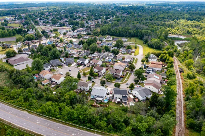 An aerial view of a residential area with a train track going through it.