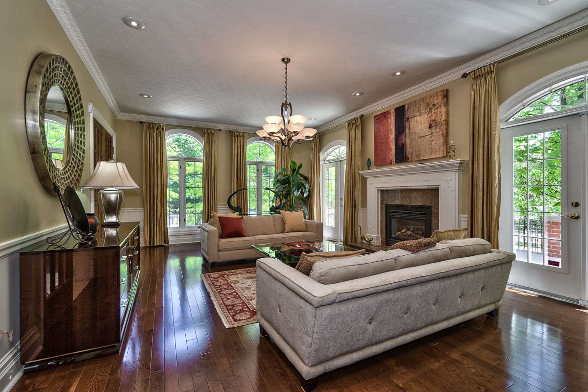 Formal living room with fireplace and arched windows in a Southeast Oakville estate home, marketed by the Dan Cooper Group.