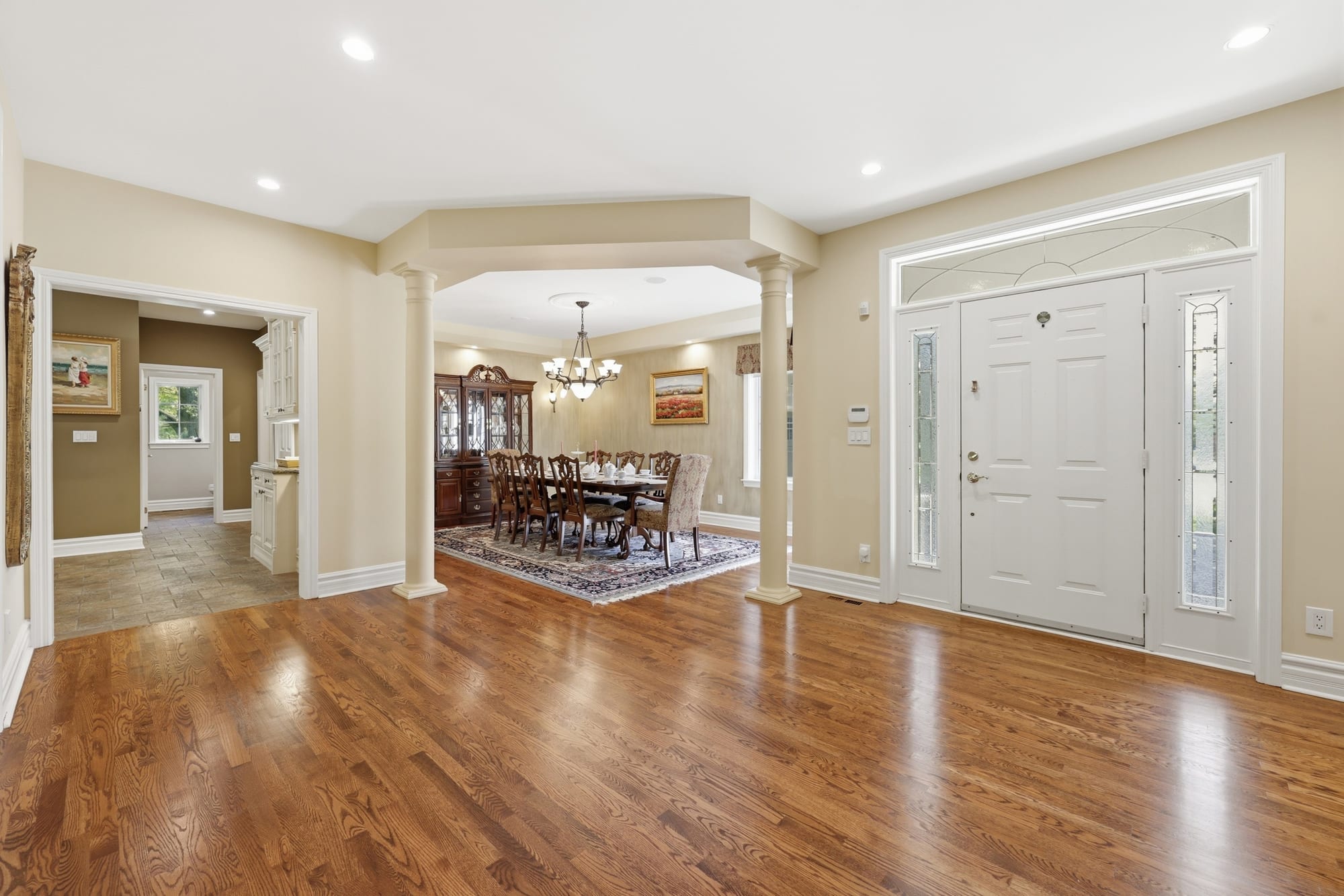 Foyer and formal dining room with hardwood floors and columns in a Southeast Oakville home, marketed by the Dan Cooper Group.