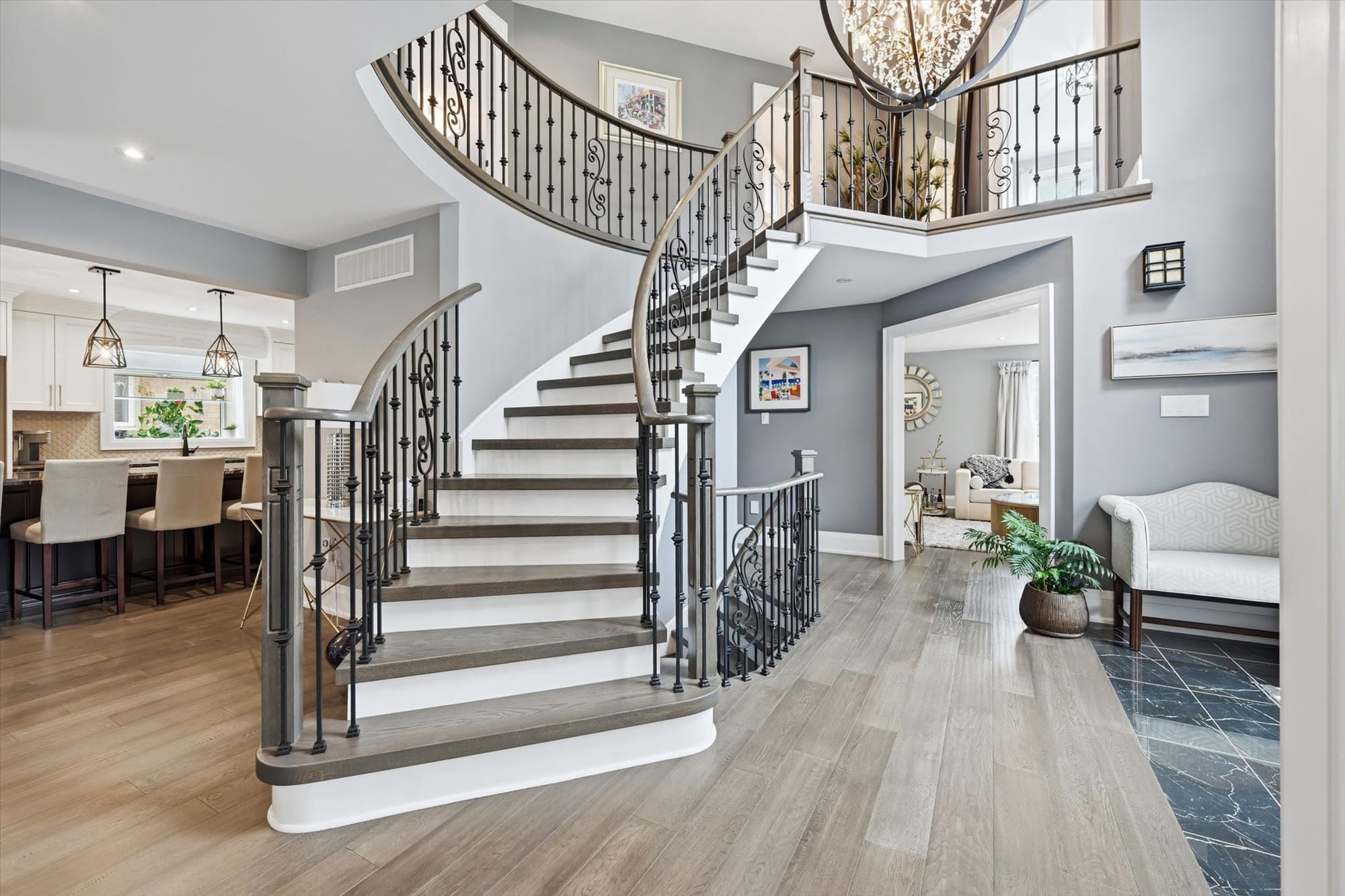 Curved staircase and open foyer of a renovated Oakville home, marketed by the Dan Cooper Group.