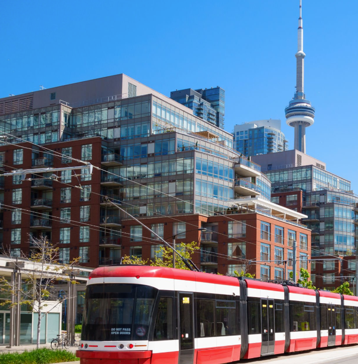 A red and white train with the cn tower in the background