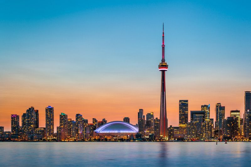 Toronto, Ontario skyline with the CN tower in the foreground and a large body of water